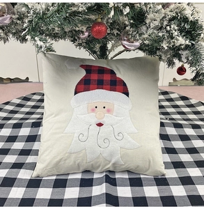 Detail of burlap Christmas pillowcase with red and black plaid Santa Claus applique