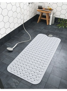 Dettaglio tappetino da bagno antiscivolo in PVC bianco con fori di drenaggio su piastrelle