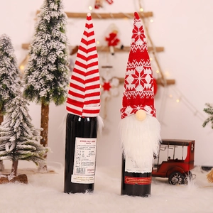 Gestrickte Weihnachtswichtel-Weinflaschenhüllen mit rot-weißen Streifen und Schneeflocken
