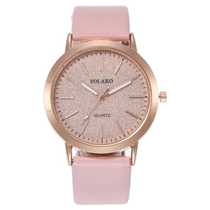Close-up of a pink glitter dial watch with a rose gold case and textured leather strap