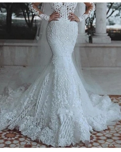 Détails de broderie en dentelle et paillettes sur une robe de mariée sirène blanche chic