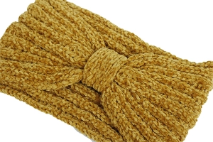 Macro shot of ginger yellow chenille knitted headband with soft braided texture and knot