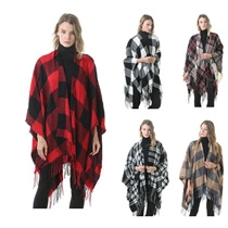 Detailed view of red and black plaid poncho featuring fringe hem and high turtleneck
