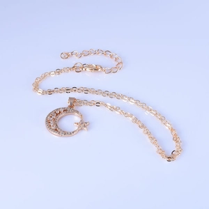 Detail of gold star and moon pendant with sparkling cubic zirconia on a delicate chain