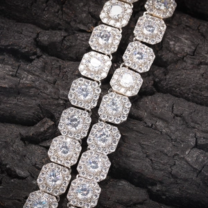 Macro view of silver-toned hip hop chain featuring square links and cubic zirconia stones