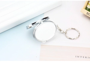 Close-up of silver metal oval flip locket keychain with DIY photo slot and polished finish