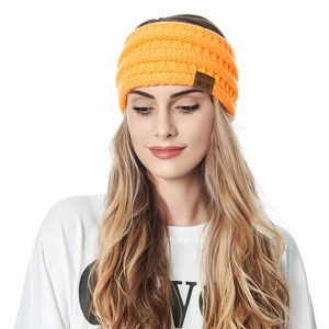 Close-up of orange knitted winter headband for women featuring a MOK leather patch detail