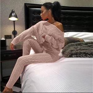 Dettaglio della trama in maglia a trecce rosa su maglione senza spalle e pantaloni