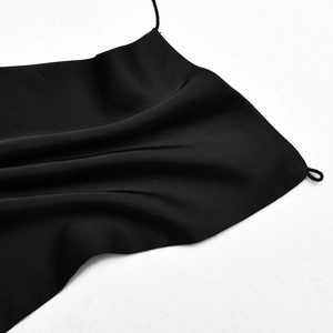 Gros plan détaillé du tissu en satin noir brillant avec de fines bretelles spaghetti