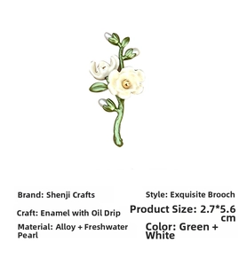 Macro detail of white enamel camellia brooch with green stem and freshwater pearl