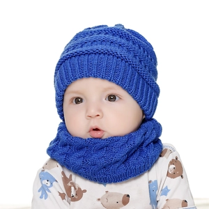 Detailansicht eines Babys mit einem hellblauen Strickmützen- und Schal-Set für den Winter