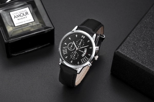 Macro view of men's quartz watch with black dial and sub-dials on textured background