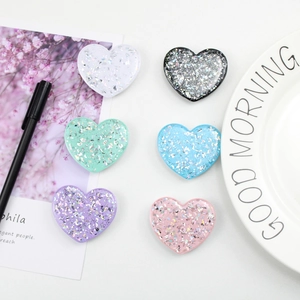 Detalle de seis soportes de móvil en forma de corazón brillante en varios colores