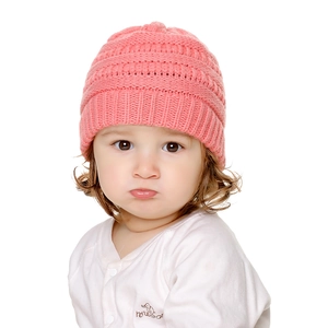 Dettaglio del cappello in maglia rosa per neonati con trama spessa a costine