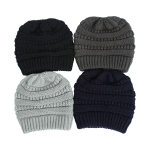 Quattro berretti in maglia nero, grigio e blu navy con trama a costine e filato caldo