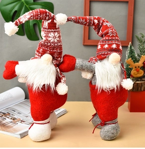 Close-up of two knit Christmas gnome curtain tiebacks with reindeer snowflake patterns