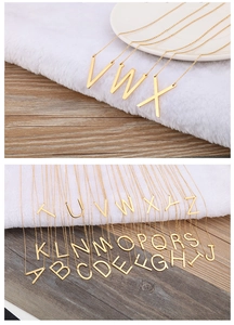 Détail de 26 pendentifs lettres en or sur des colliers en acier inoxydable de qualité