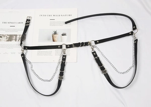Macro shot of punk style heart-shaped metal buckle and adjustable straps on black leg ring