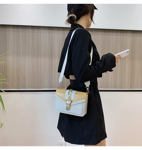 Detail of blue and white color-block crossbody bag on black dress model with wide strap