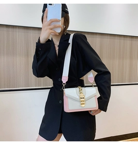 Pink and white patchwork crossbody bag shown on a black suit jacket in a mirror selfie