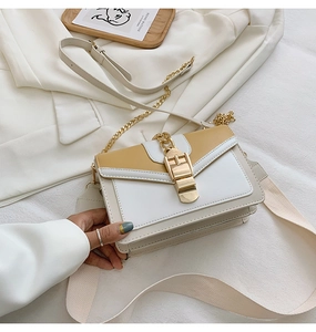 Detail of PU leather shoulder bag with yellow contrast, chain strap and gold buckle lock