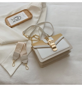 Chic yellow and white color-block crossbody bag with gold hardware on white fabric