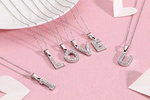 Détail du collier argenté avec pendentifs lettres I LOVE U sertis de cristaux brillants