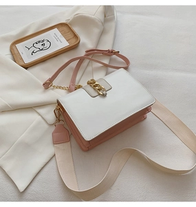 Detail of pink and white crossbody bag with gold chain and two shoulder straps