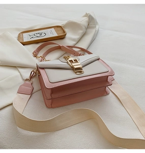 Detail of pink and white crossbody bag with gold buckle and wide canvas shoulder strap