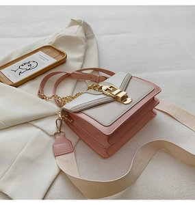 Detail of cream and pink crossbody bag with gold buckle and wide fabric strap