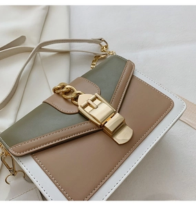 Close-up of tricolor PU leather shoulder bag with gold chain and metal buckle
