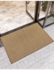 Dettaglio macro dello zerbino in fibra marrone con trama ruvida e bordo resistente