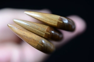 Macro detail of natural sandalwood comb handle showing smooth wood grain and seamless joints