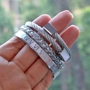 Detailed shot of silver stainless steel Roman numeral cuff and braided metal bracelet set