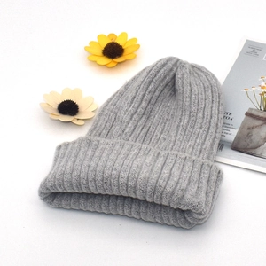 Close-up of a light grey knitted beanie showing thick textured wool and folded cuff detail