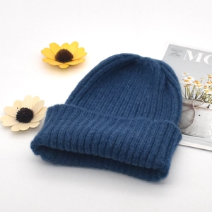 Detail of dark blue chunky knit beanie showing the vertical ribbed texture and rolled cuff