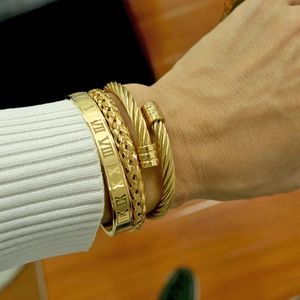 Three-piece gold stainless steel bracelet set with roman numerals and twisted textures
