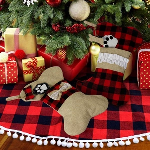 Detail of bone-shaped Christmas stockings in plaid and burlap on a festive tree skirt
