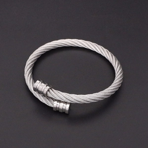Détail macro du bracelet câble torsadé en acier inoxydable argenté au style industriel