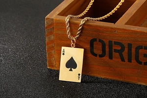 Macro shot of gold Ace of Spades poker card pendant with zircon inlay on a wooden box