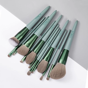 Close-up of premium cosmetic brushes with matte green handles and soft synthetic bristles