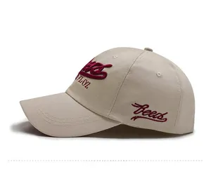 Detail view of beige cotton baseball cap featuring high-quality burgundy 3D embroidery