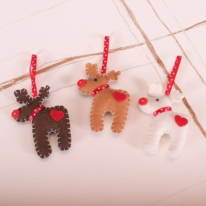 Three felt reindeer Christmas tree ornaments in brown and white on marble background