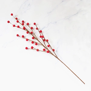 Close-up of vibrant red artificial Christmas berries on branch for festive home decoration