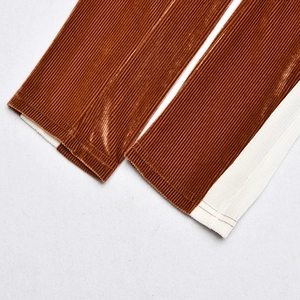 Détail d'une combinaison en velours marron avec bordure blanche et texture à rayures