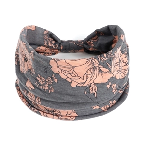 Détail macro d'un bandeau large élastique avec motifs floraux corail sur fond gris foncé