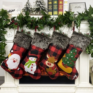 Set of four buffalo plaid Christmas stockings with faux fur hanging on a cozy white fireplace