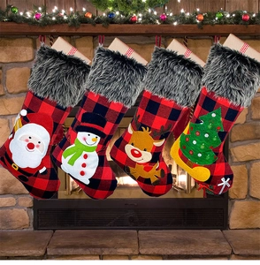 Set of four buffalo plaid Christmas stockings with faux fur hanging on a cozy fireplace