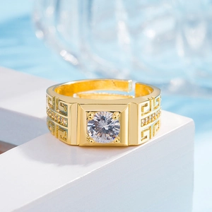 Dettaglio anello dorato con moissanite, motivo a greca e montatura a sei griffe