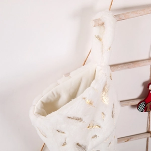 Chaussette de Noël blanche en fausse fourrure avec plumes dorées sur échelle en bois
